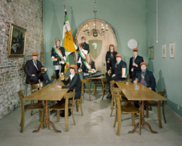 Inszeniertes Gruppenbild der Studentenverbindung 'Akademische Verbindung Froburger'. Alle stehen oder sitzen in Ihren Uniformen um einen Tisch.