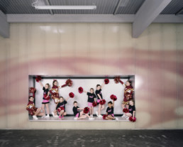 Inszeniertes Gruppenbild von Cheerleaderinnen, welche zusammen in ihren Auftrittskostümen posieren.